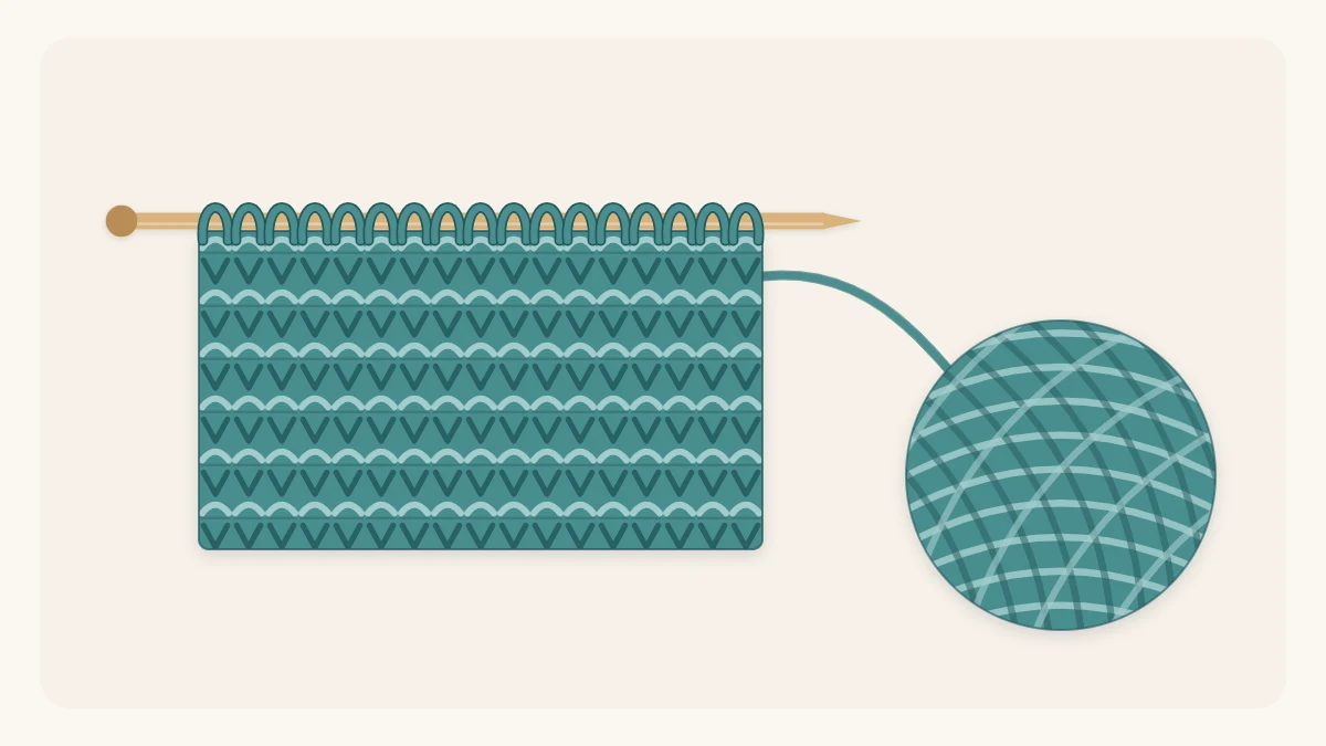A garter stitch swatch with horizontal ridges on a knitting needle beside a ball of yarn